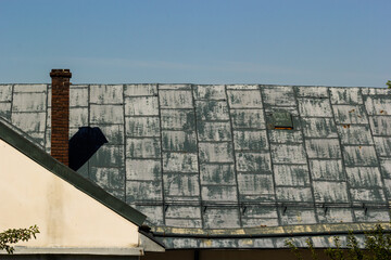 Metal roof of a detached house and chimney against the sky, metal roof tiles, gutters