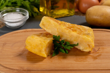 Spanish omelette with potatoes and onion, typical Spanish cuisine. Tortilla espanola. Rustic dark background