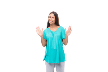 portrait of a doubting young caucasian brunette woman in a blue t-shirt on a white background with copy space