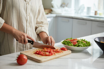 Cropped image of housewife cutting juicy tomatoes for salad