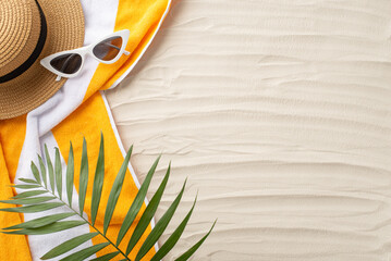 Beach paradise awaits. Top view of summer accessories: sunglasses, headwear, yellow towel, and palm...