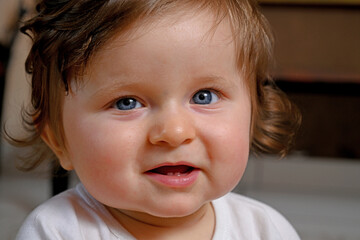 portrait of a young smiling baby with blue eyes