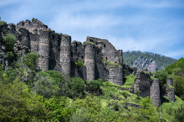 Fototapeta na wymiar ancient temple and the ruins of the fortress wall in the mountains of Armenia