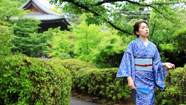 gorgeous Japanese woman in a kimono dancing in front of a pagoda in traditional Japanese garden in Tokyo, Japanese cultural heritage, diversity concept