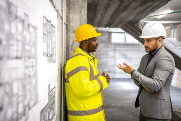 Construction site meeting. Structural engineer and architect discussing about new building project.