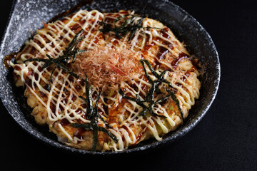 Okonomiyaki traditional japanese food isolated in black background
