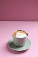 hot cappuccino with latte art isolated in pink background