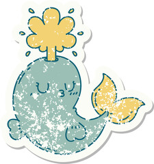 worn old sticker of a tattoo style happy squirting whale character