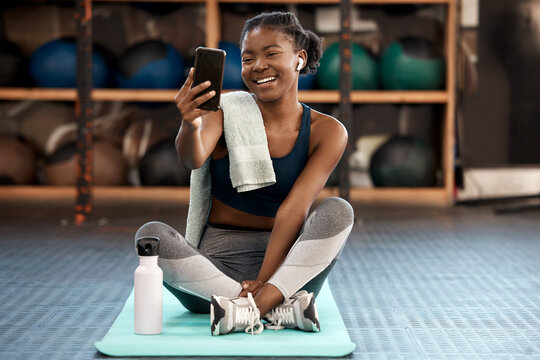 Phone, selfie and black woman fitness influencer on social media on a cellphone during workout or exercise in a gym. Health, wellness and young person or athlete happy online, internet or web