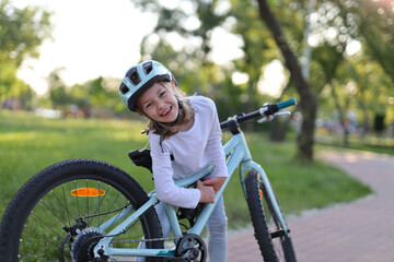 Smiling girl rider takes water out of the bike.