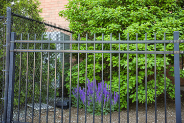 Metal fence symbolizes boundaries, security, protection, privacy, and delineates spaces with its strong and sturdy presence