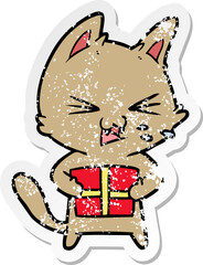 distressed sticker of a cartoon hissing cat with christmas present