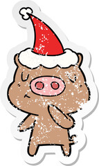 hand drawn distressed sticker cartoon of a content pig wearing santa hat