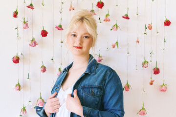 Studio portrait of pretty young teenage 15 - 16 year old girl wearing denim jacket, posing on white...