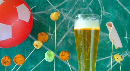 Soccer or football concept with soccer ball, glass of beer, pork sausage and snacks