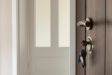 Open door to a new home. Door handle with keys. Mortgage, investment, real estate, property and new home concept