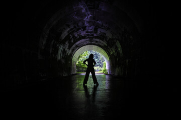 古いトンネルの中に立つ女性のシルエット