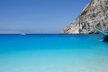 turquoise water seen from the Navagio beach with high cliffs, touristic famous landmark on Zakynthos island, Greece