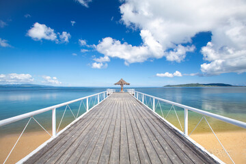 Obraz premium 美しいビーチに伸びる桟橋とパラソル