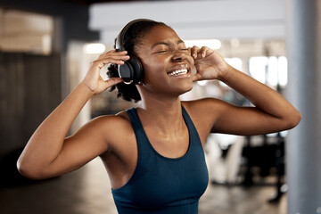 Black woman, fitness and listening to music on headphones in workout, exercise or training at gym....