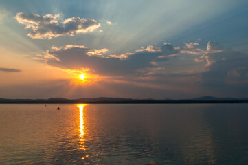 Summer sunset landscape - the Irtyash Lake in Southern Urals, Russia, rippled water surface lit by sunset summer light
