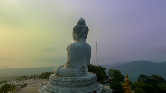 Aerial hyperlapse view of the sun shining through the fog covering Phuket big Buddha..Fog around Phuket big Buddha at a sweet sunrise..The beauty of the statue fits perfectly with the charming nature
