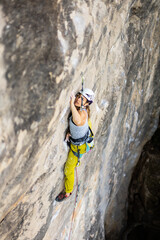 woman climbing big walls in the mountains, doing sports, striving hard for her goals without fear of success, courageous person, confident person with commitment.