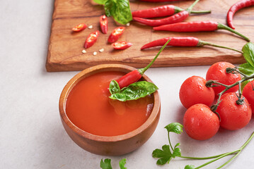red hot chilli sauce. tomato ketchup, chilli sauce, puree with chili pepper, tomatoes and garlic. on wooden cutting board on stone background. top view.