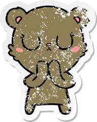 distressed sticker of a peaceful cartoon bear cub