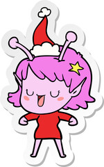 happy alien girl hand drawn sticker cartoon of a wearing santa hat