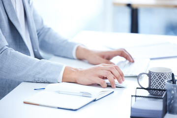 Keyboard, hands and closeup of a woman typing on computer for research in the office. Technology, professional and female employee working on corporate project with desktop and notebook in workplace.