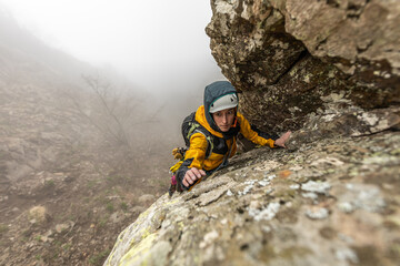 Obraz premium woman climbing high mountains in the Pyrenees dramatic sunset sky, valley with trees, high peaks,