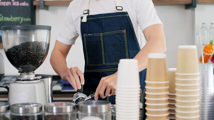 Close up hands of professional men barista in apron making coffee, latte and espresso for customer service. Coffee shop owner is preparing drinks in coffee shop, cafe