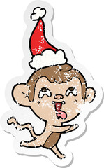 crazy hand drawn distressed sticker cartoon of a monkey running wearing santa hat