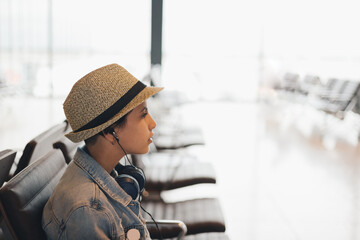 Teenage girl with headphones in an airport waiting lounge