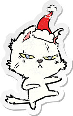 tough hand drawn distressed sticker cartoon of a cat wearing santa hat