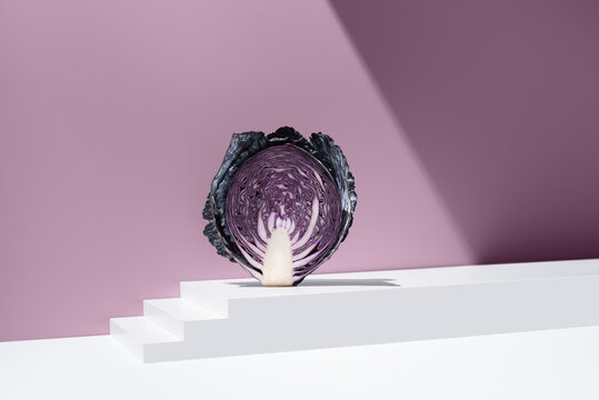 Sliced purple cabbage on pink background in studio