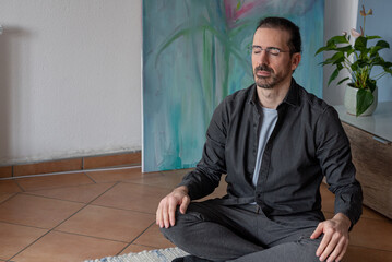 man sitting in the lotus position on the floor