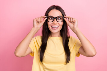 Photo of adorable excited lady wear yellow t-shirt arms spectacles big eyes isolated pink color background