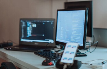 Computer screens running programming code in empty software developing agency office and computers...