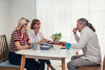 Members of the family from multiple generations enjoy quality time together by eating, snacking, chatting, discussing, learning about each other's interests, and strengthening stronger relationships.