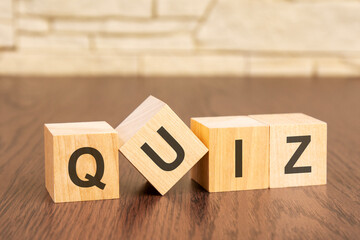 wooden blocks with word QUIZ on dark wooden background. frequently asked question concept