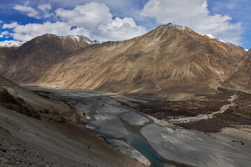 Captivating Suru Valley as it winds through the majestic mountains, while the shimmering Indus River flows under the sunny sky in Ladakh region, India