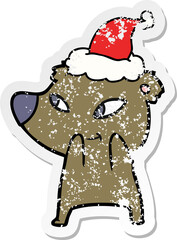 cute hand drawn distressed sticker cartoon of a bear wearing santa hat