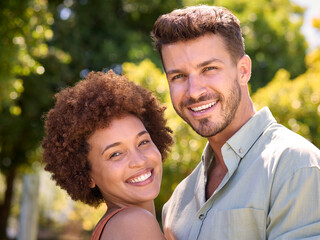 Portrait Of Loving Multi-Racial Couple Standing Outdoors In Garden Park Or Countryside