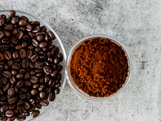 Coffee beans served in saucer with defocused coffee powder