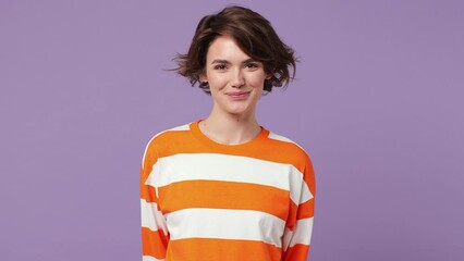 Young positive smiling happy fun cheerful calm satisfied caucasian woman wearing casual clothes look camera isolated on plain pastel light purple background studio portrait. People lifestyle concept