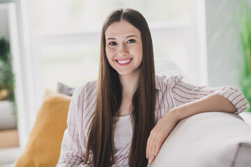 Obraz premium Photo of adorable dreamy young lady dressed striped shirt sitting couch smiling indoors house room