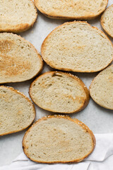 Naklejka premium Top view of slice of toasted bread on a marble counter, slices of bread on a cutting bread, cut french bread