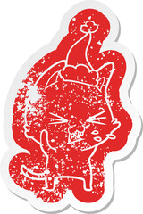 quirky cartoon distressed sticker of a cat hissing wearing santa hat